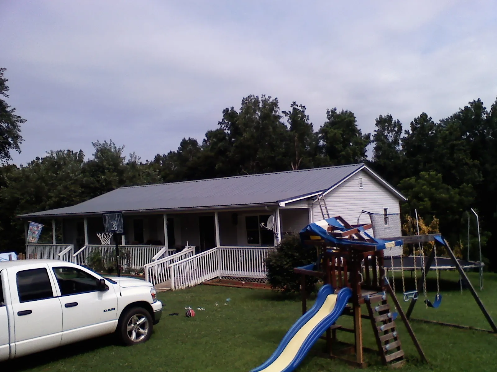 Dark metal roof on a country home with a full length front porch in Dearborn