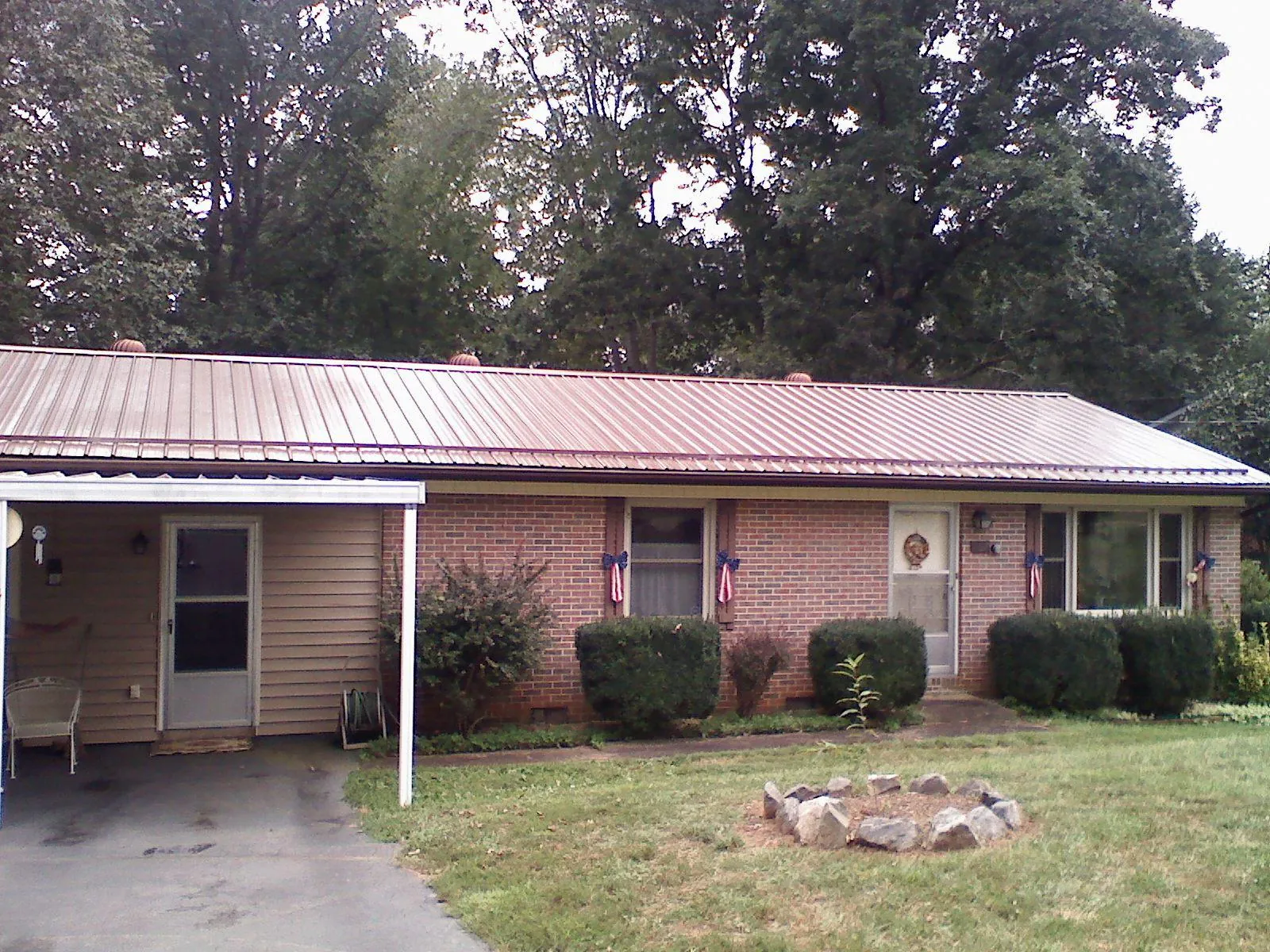 Bronze metal roof and carport on a brick ranch home — Roof Repair work by our crew in Dearborn